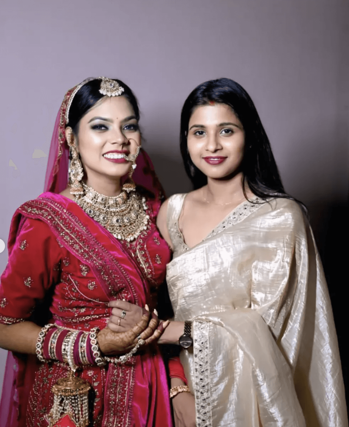 Shalinee standing beside radiant smiling bride wearing full bridal jewelry and lehenga