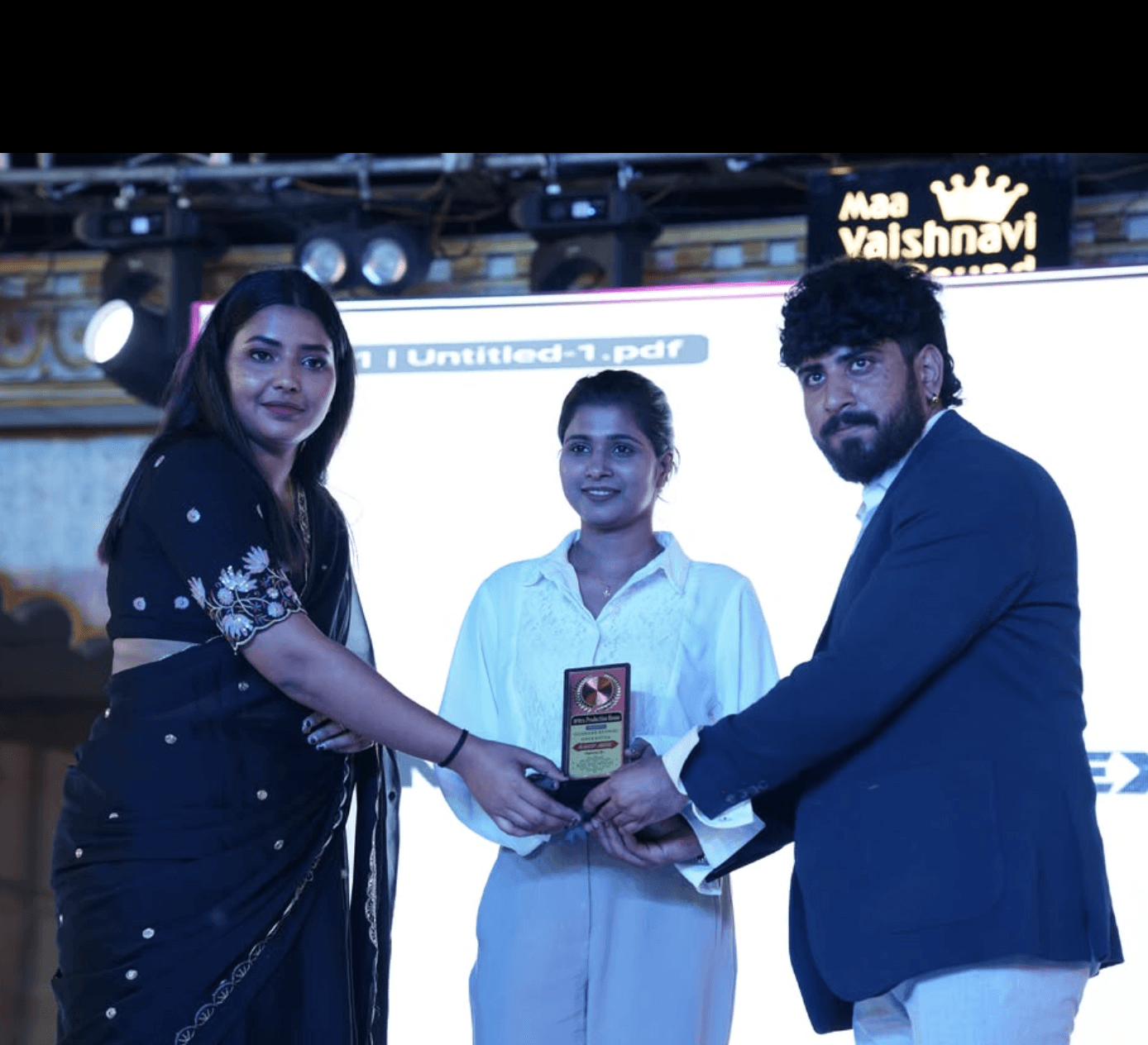 Shalinee receiving prestigious memento trophy on stage from dignitaries